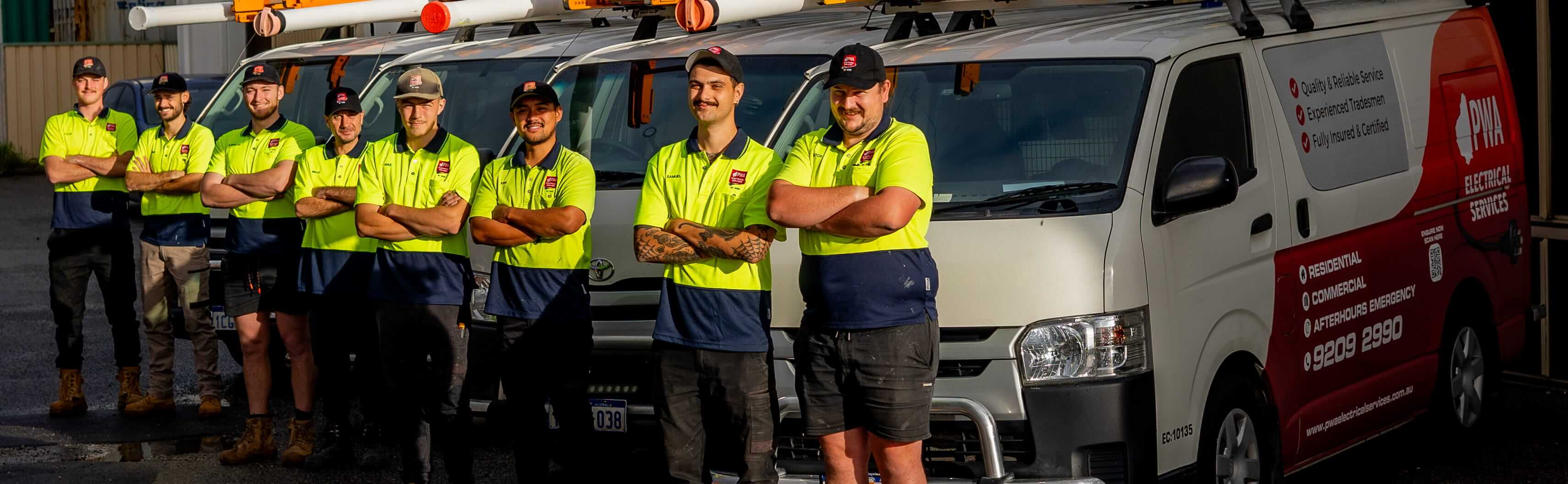 PWA Electrical Services team of electricians standing in front of branded service vans at their Perth depot.