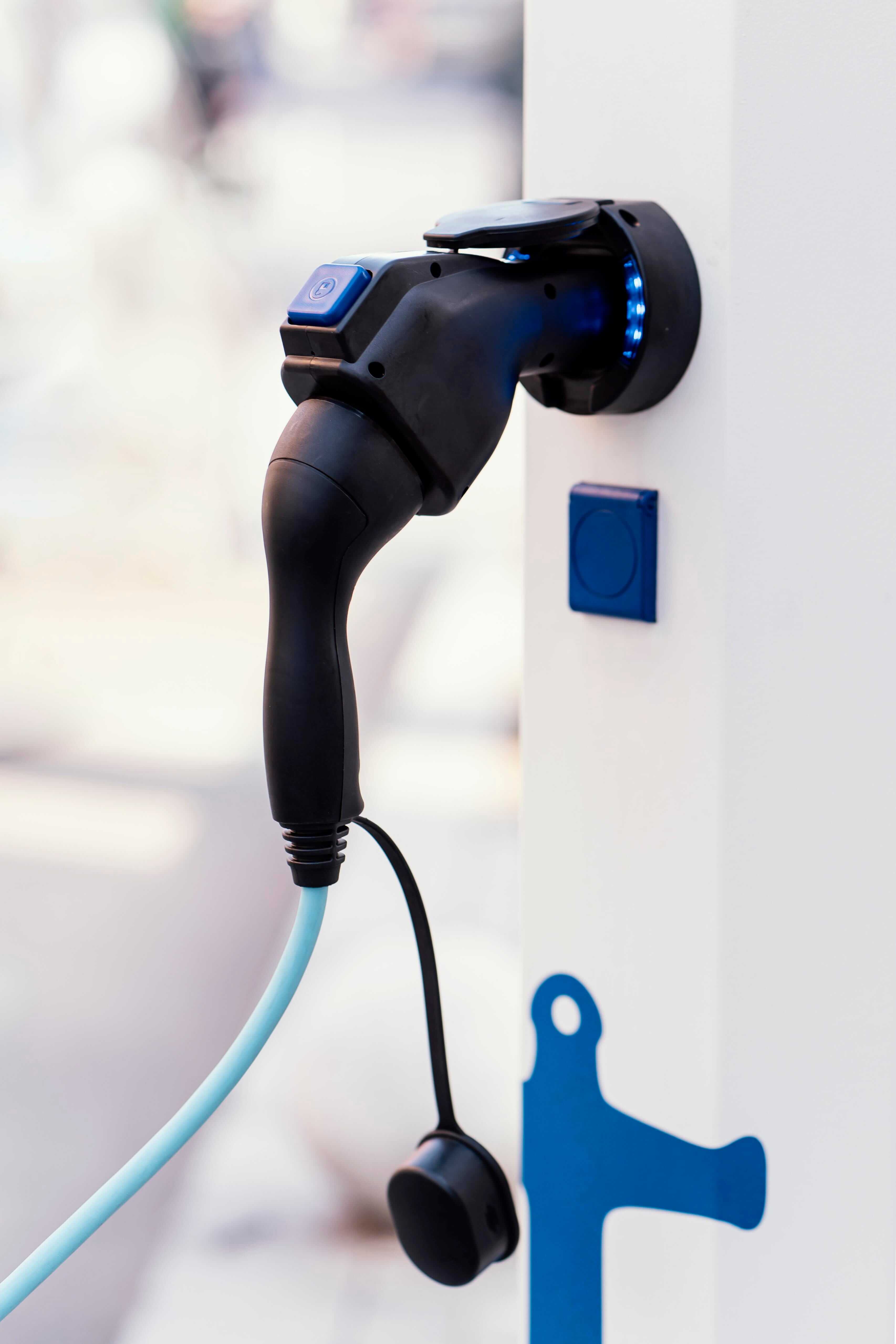 Electric vehicle charging connector plugged into a charging station.